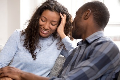happy-couple-relaxed-on-couch-talking-holding-hands