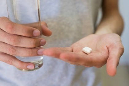 hands-with-pills-and-a-glass-of-water