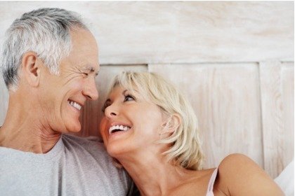 happy mature couple in bed looking at each other