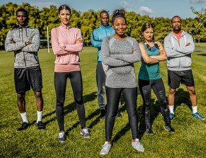 group of young athletes standing with arms crossed