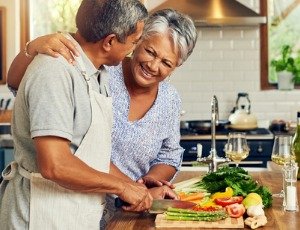 African American couple cooking healthy meal in kitchen