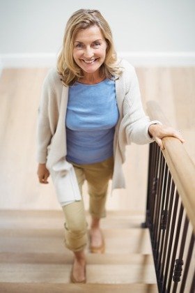 smiling woman walking up stairs