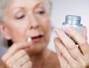 woman looking at supplement bottle label